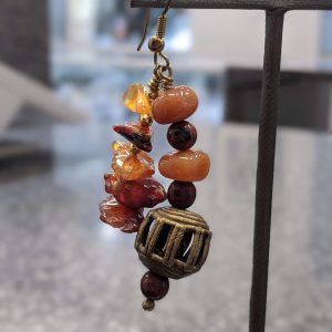 ASSORTED HARD STONE EARRINGS WITH METAL PIECES IN BETWEEN AND A METAL LANTERN SHAPED PIECED AT BOTTON OF EACH EARRING. HAS A NECKLACE TO MATCH.