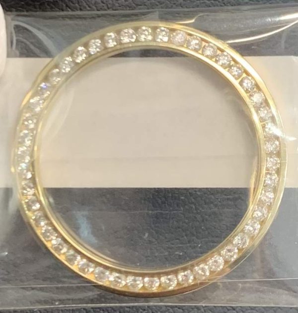 18K Y/G LADIES CHANNEL SET DIAMOND BEZEL FEATURING 1 CARAT OF ROUND BRILLIANT CUT DIAMONDS.