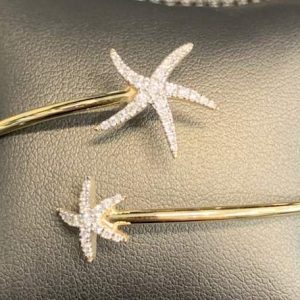 14K Y/G LADIES NAUTICAL STAR FISH BANGLE BRACELET CONSISTING OF 39 PAVE SET ROUND BRILLIANT CUT DIAMONDS ON THE STARFISH WEIGHING .31 PTS. 3.1 DWT.