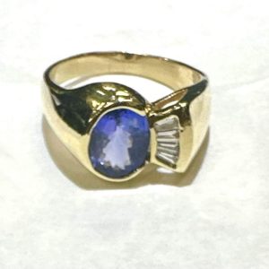 14K Y/G DIAMOND AND TANZANITE FASHION RING CONSISTING OF 0.25 PTS OF BAGUETTES AND AN OVAL TANZANITE MEASURING 9MM X 7MM. 5.7 DWT. SIZE:9.5.