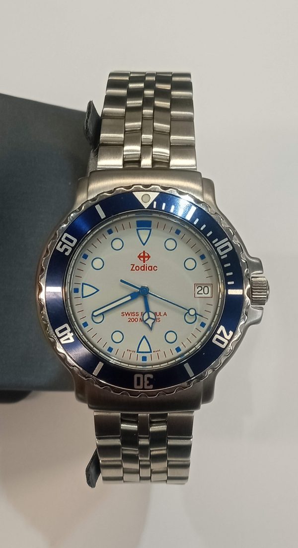 S/S ZODIAC WATCH WITH WHITE DIAL AND BLUE BEZEL W/DATE WINDOW. NO BOX OR PAPERS.